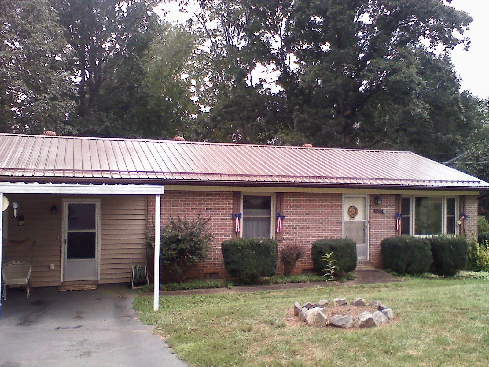 Bronze metal roof and carport on a brick ranch home — Roof Repair work by our crew in Oswego